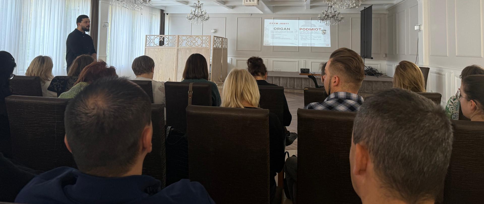 Grupa osób na sali szkoleniowej