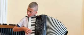 Wykonawca przy instrumencie na scenie w sali koncertowej podczas Uroczystego Koncertu Absolwentów