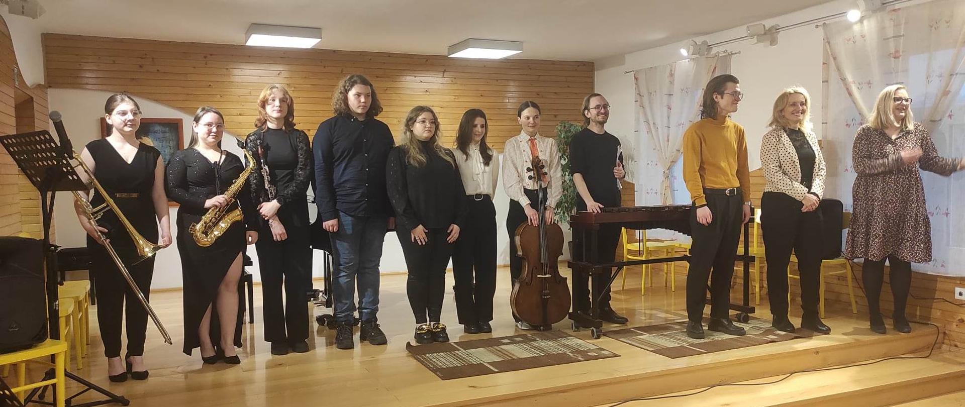 występujący uczniowie PSM II stopnia w Kutnie z akompaniatorem, nauczycielką i kierowniczką PSM Koło