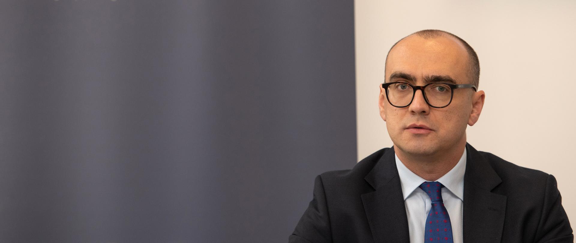 Otpravnik poslova Bartoš Marcinkovski na konferenciji, u pozadini logo Ambasade Republike Poljske sa grbom na plavoj podlozi