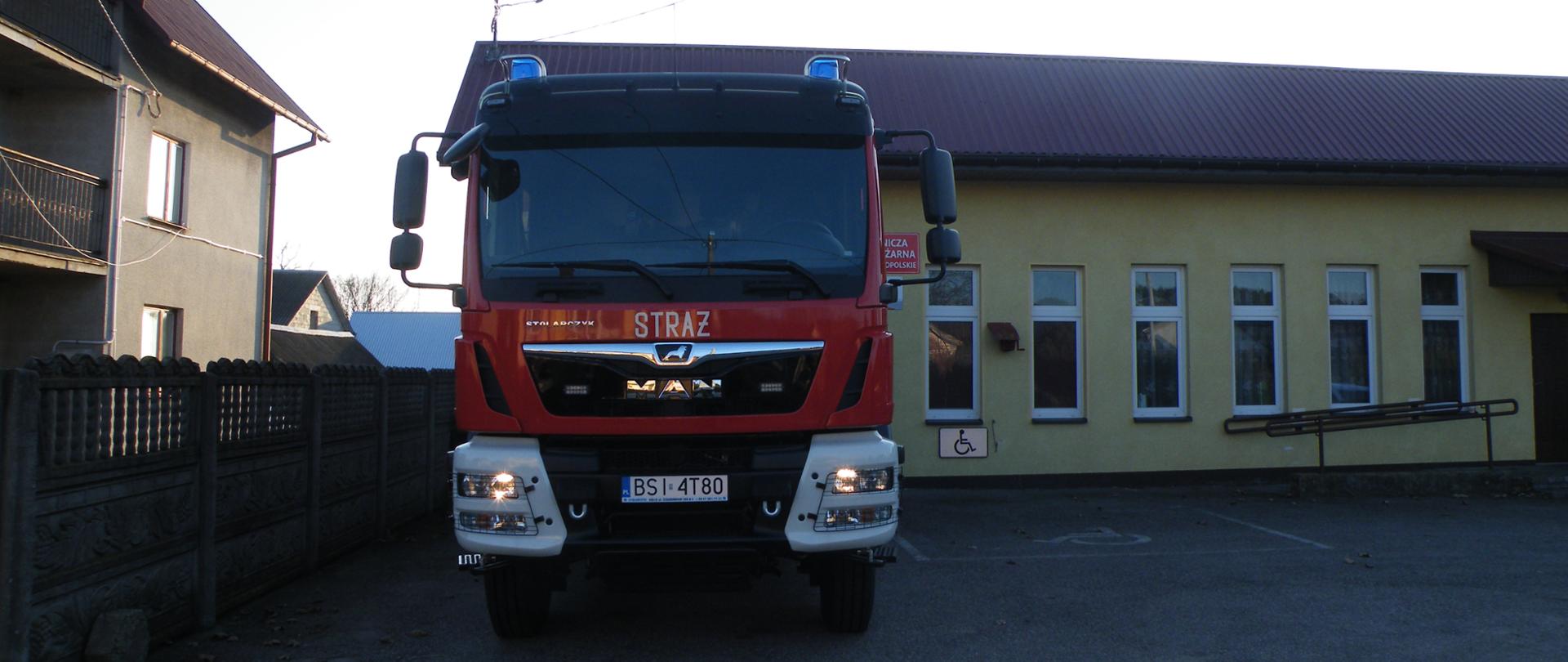 Budynek strażnicy OSP Słochy Annopolskie, przed budynkiem samochód pożarniczy.