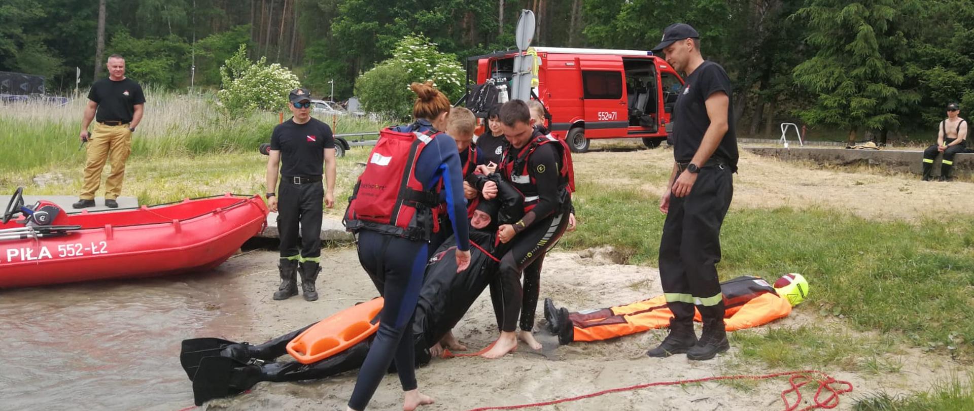 Na zdjęciu widać strażaków oraz studentów podczas wspólnych ćwiczeń.