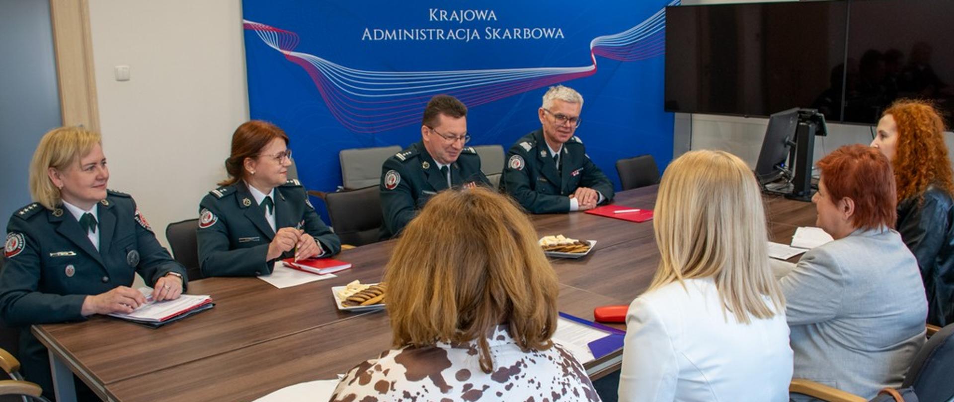 Uczestnicy spotkania siedzą przy stole