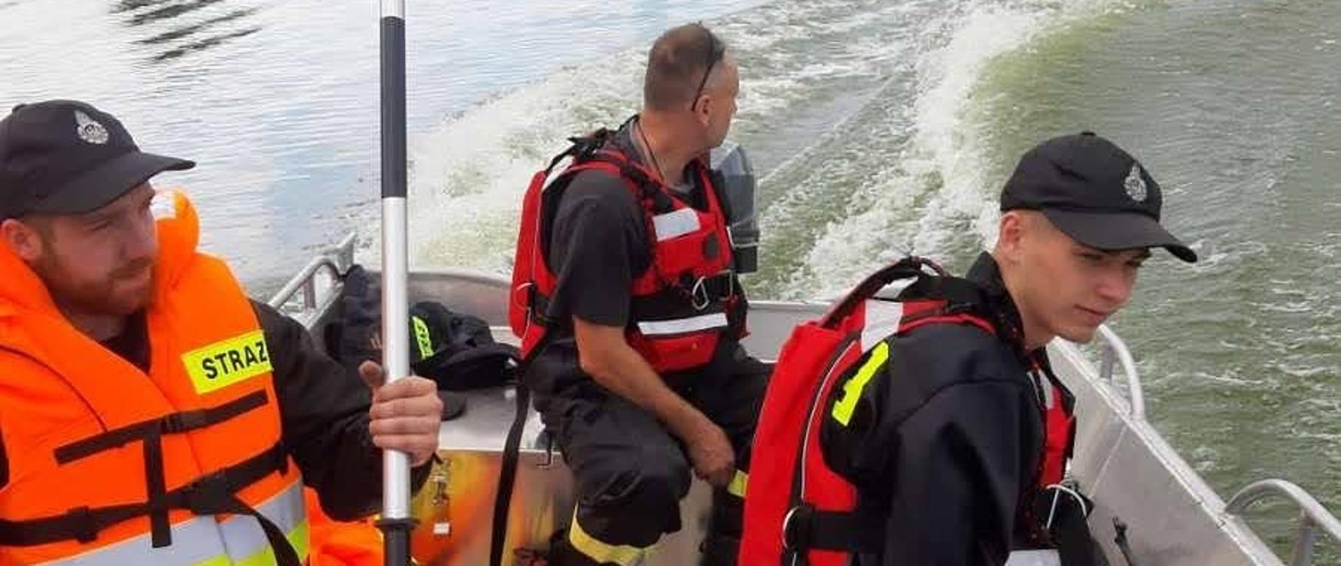 Trzech ratowników w łodzi podczas ćwiczeń na jeziorze.