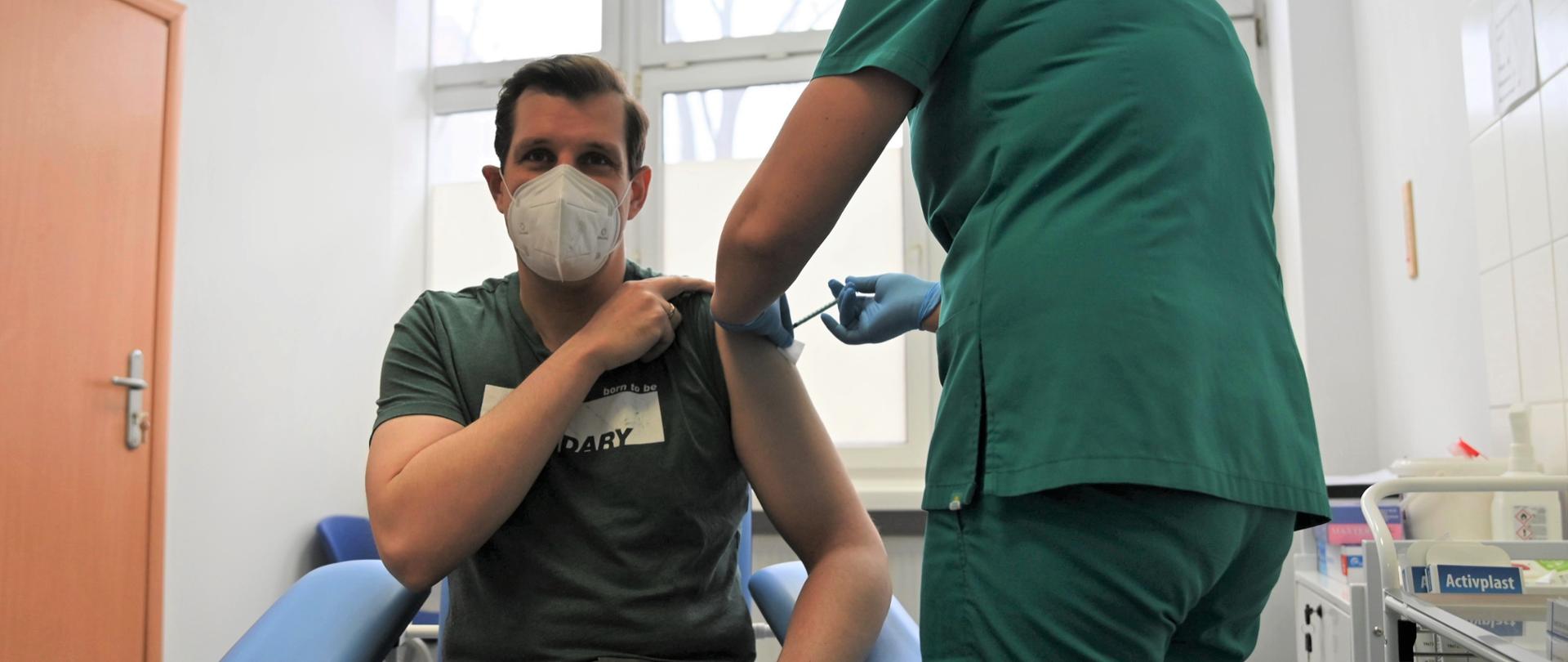 Wojewoda łódzki w trakcie przyjmowania dawki przypominającej szczepionki przeciwko COVID-19