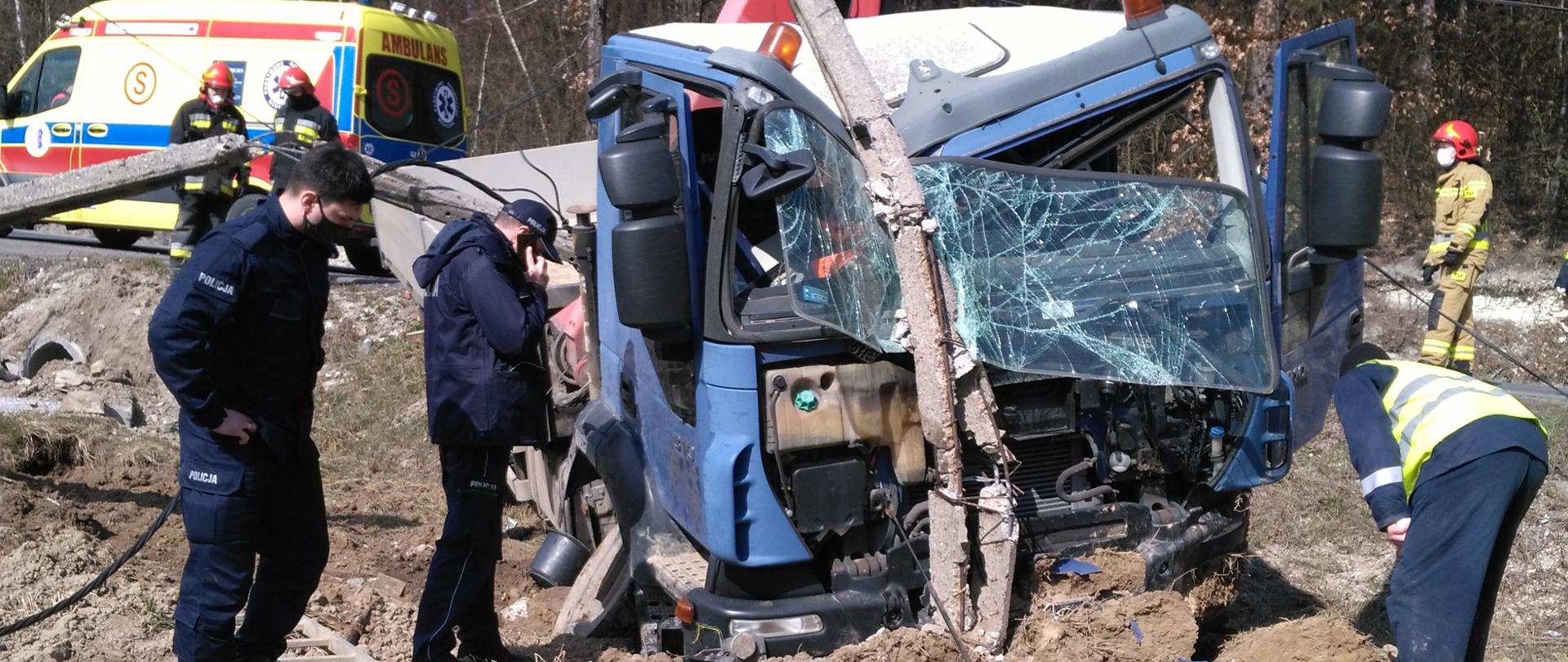 Na miejscu widać rozbity samochód dostawczy , który uszkodził słup energetyczny, obok policjanci prowadzących oględziny