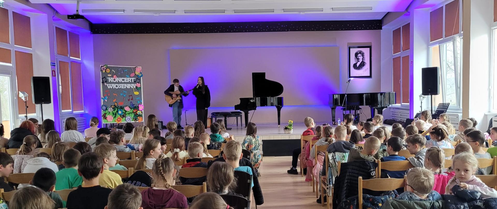 na scenie grający i śpiewający uczniowie