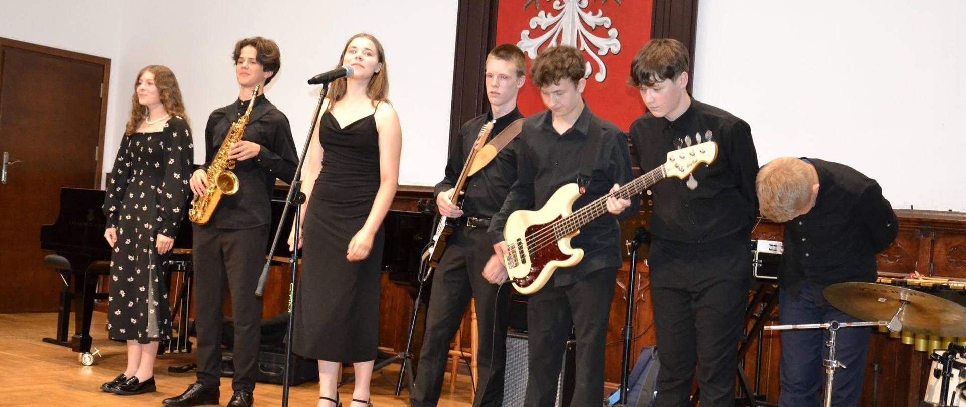 zespół szkolny występujący podczas zakończenie roku szkolnego na scenie w Sali królewskiej 