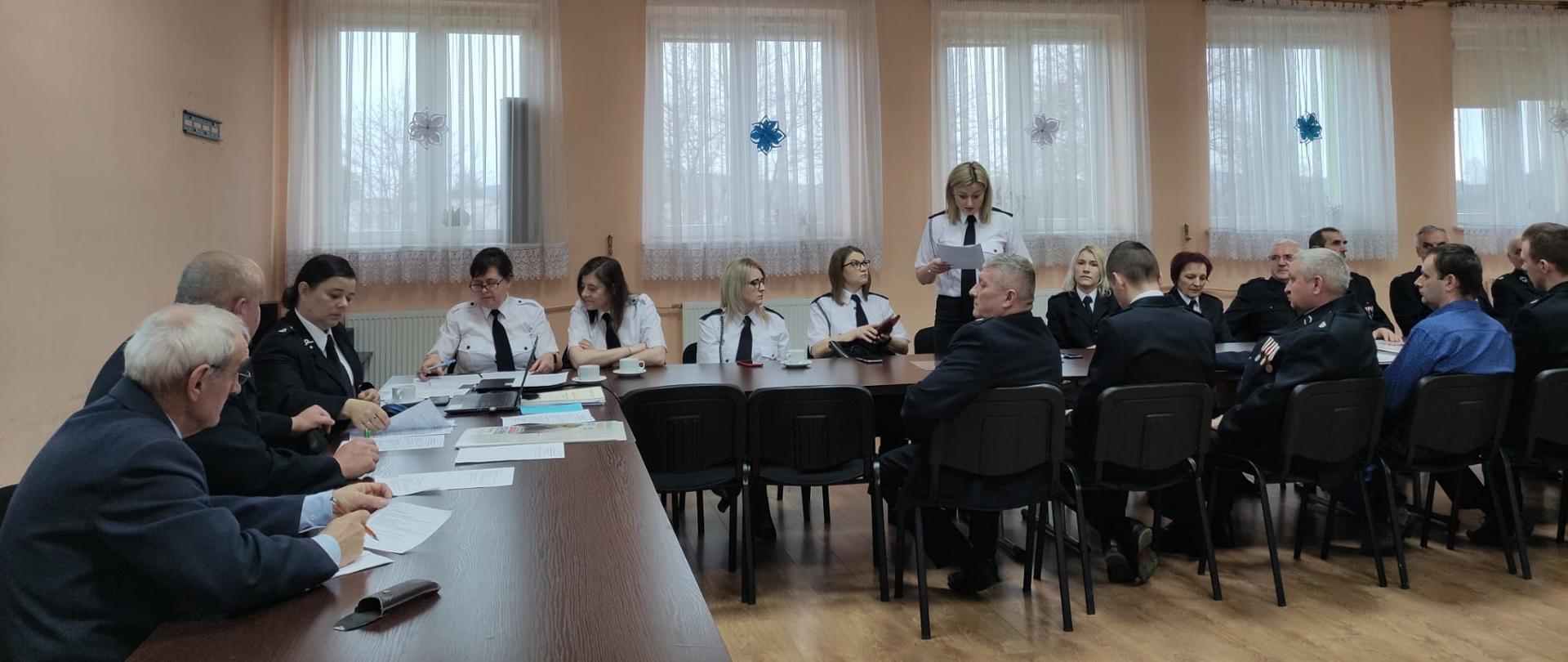 Zdjęcie przedstawia zebranych na spotkaniu wigilijno - noworocznym druhów oraz zaproszonych gości podczas prezentacji.