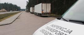 Ciężarówki zatrzymane na krajowej „dziewiętnastce”. Na pierwszym planie furgon Inspekcji Transportu Drogowego, w tle zatrzymane do kontroli samochody ciężarowe. W oddali po lewej ruch na drodze krajowej.