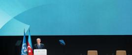 Wystąpienie Prezydenta COP29. Widoczne flagi ONZ i Azerbejdżanu. W tle logotypy UNFCCC i COP29.