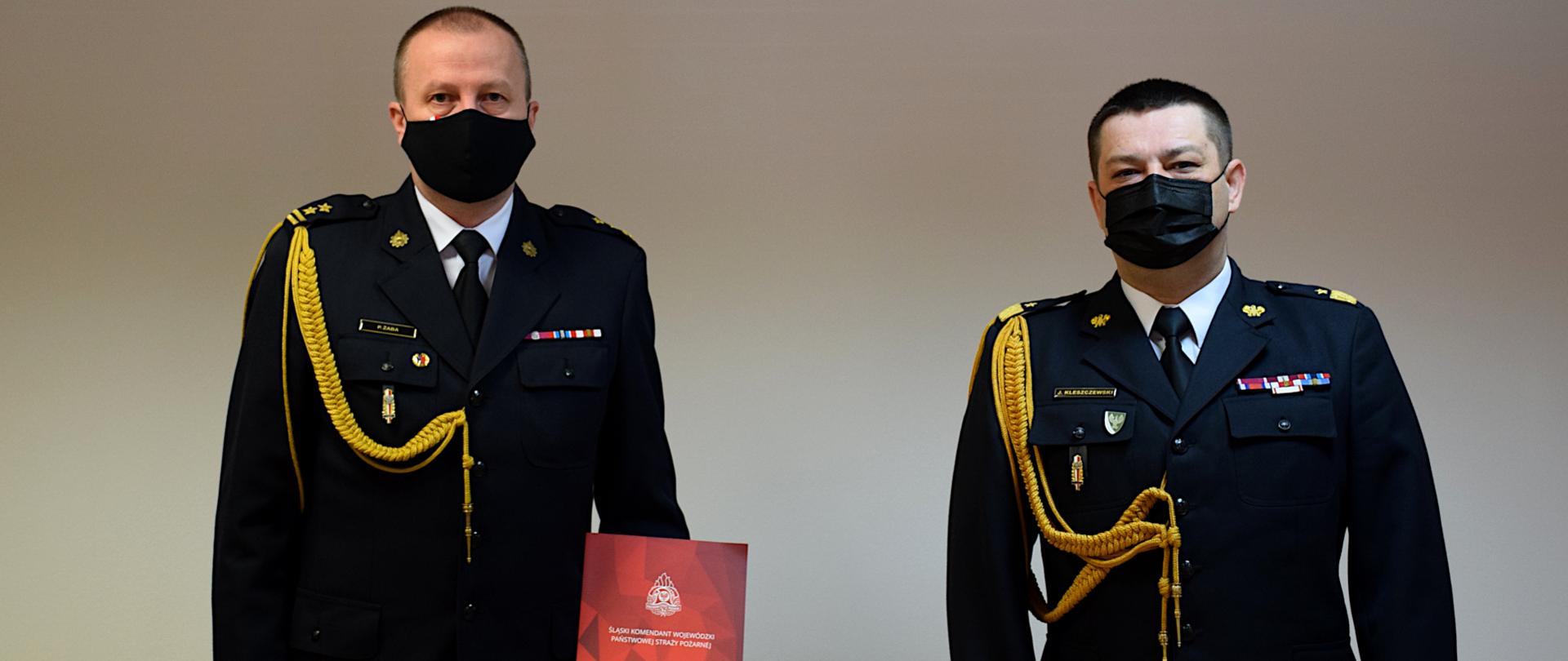 Na zdjęciu, od prawej stoi Śląski Komendant Wojewódzki PSP w mundurze galowym i maseczce ochronnej .Po lewej stronie stoi w mundurze galowym i maseczce ochronnej, powołany Komendant Miejski PSP w Jaworznie, bryg. Paweł Żaba. 
