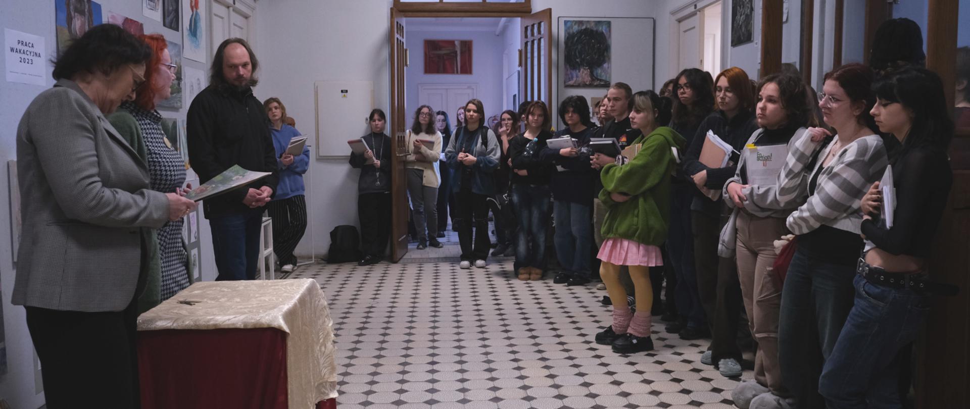 Na zdjęciu z lewej dwie kobiety i mężczyzna w roli prowadzących spotkanie. Na środku i po prawej duża grupa młodych ludzi.