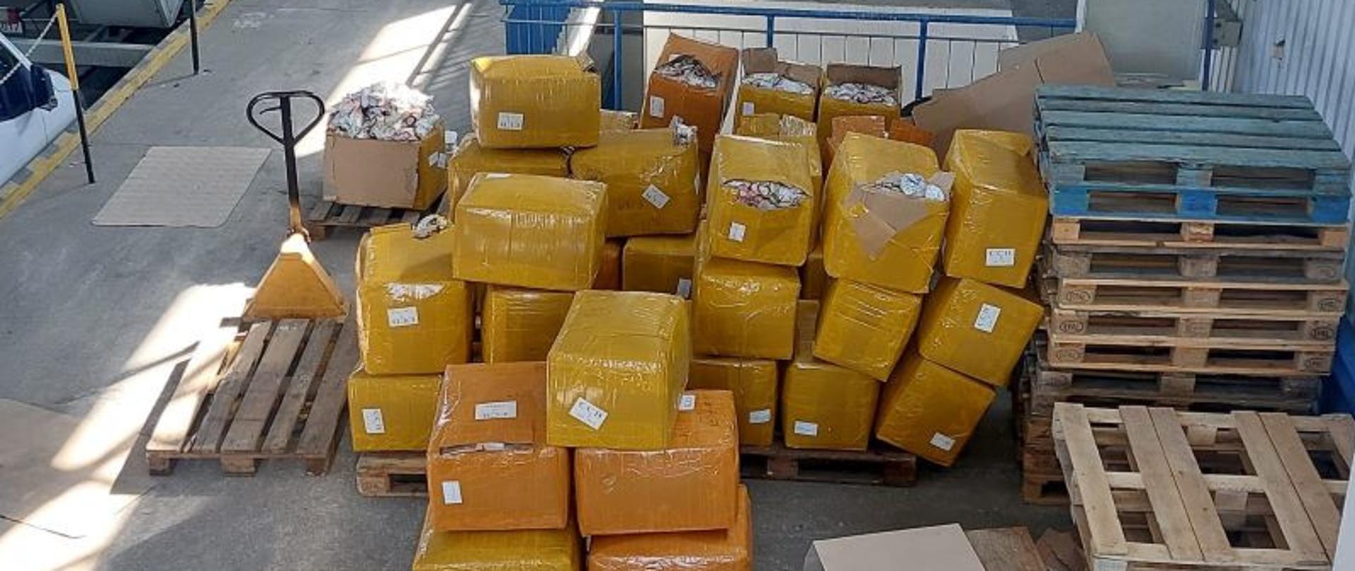 Magazyn z pudłami i paletami.