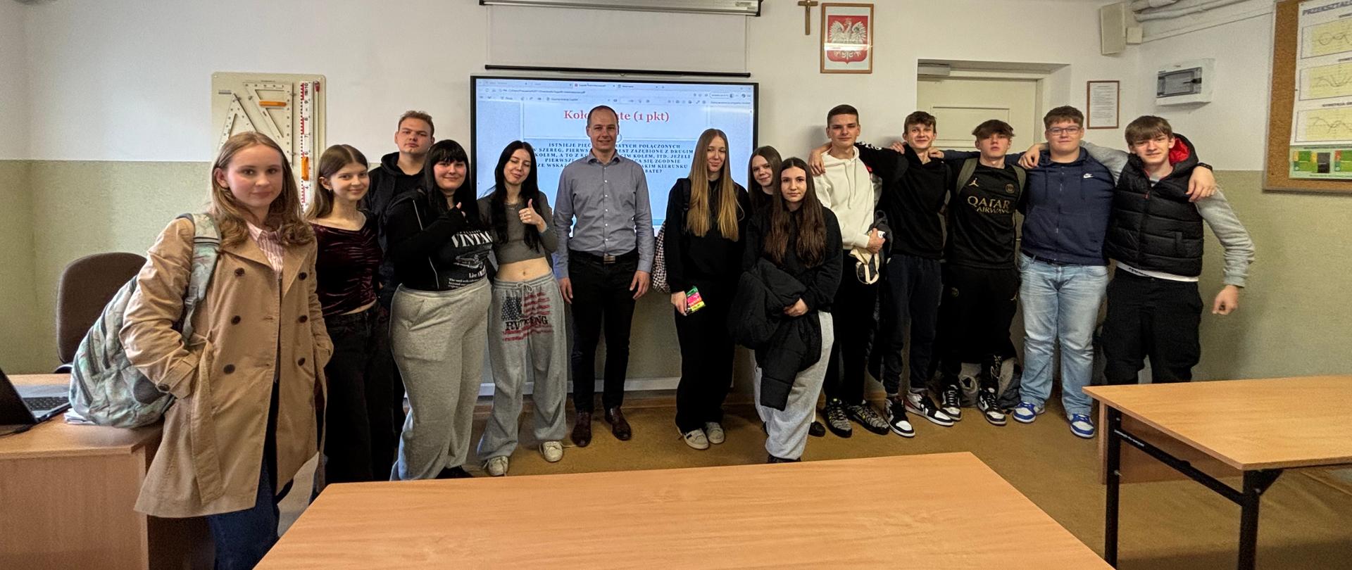 Uczniowie szkół podstawowych w klasie fizycznej z nauczycielem 