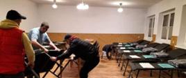 Na zdjęciu widoczne miejsca noclegowe przygotowane przez strażaków OSP między innymi łóżka polowe, stoliki, koce, rozłożone w remizie OSP w Bieczu na sali.