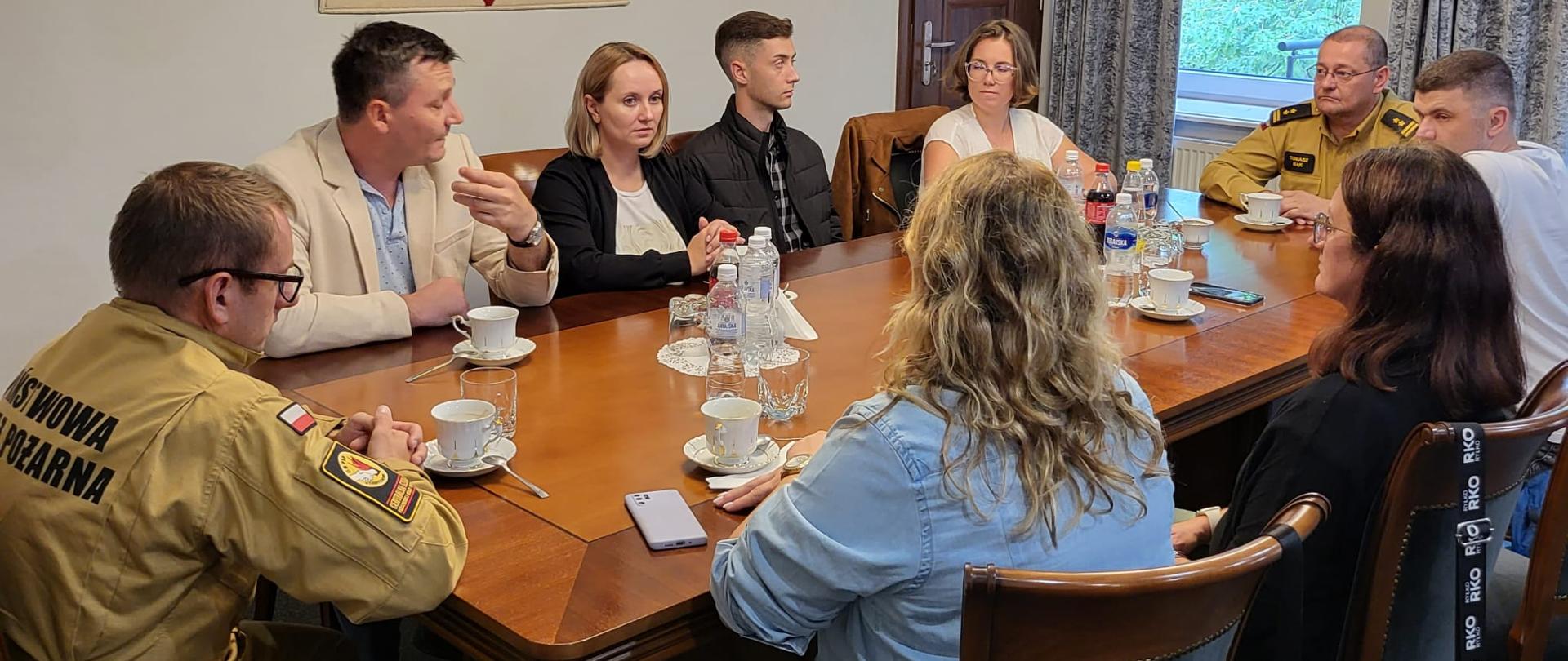 W gabinecie Komendanta Centralnej Szkoły PSP za stołem siedzą: Zastępca Komendanta CS PSP, przedstawiciele strony mołdawskiej, tłumaczka oraz oficer CS PSP. W tle na ścianie godło państwowe