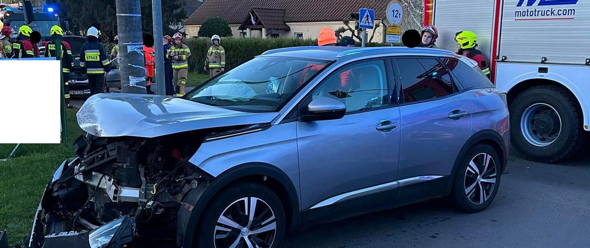 Uszkodzony samochód na drodze, w pobliżu osoby
