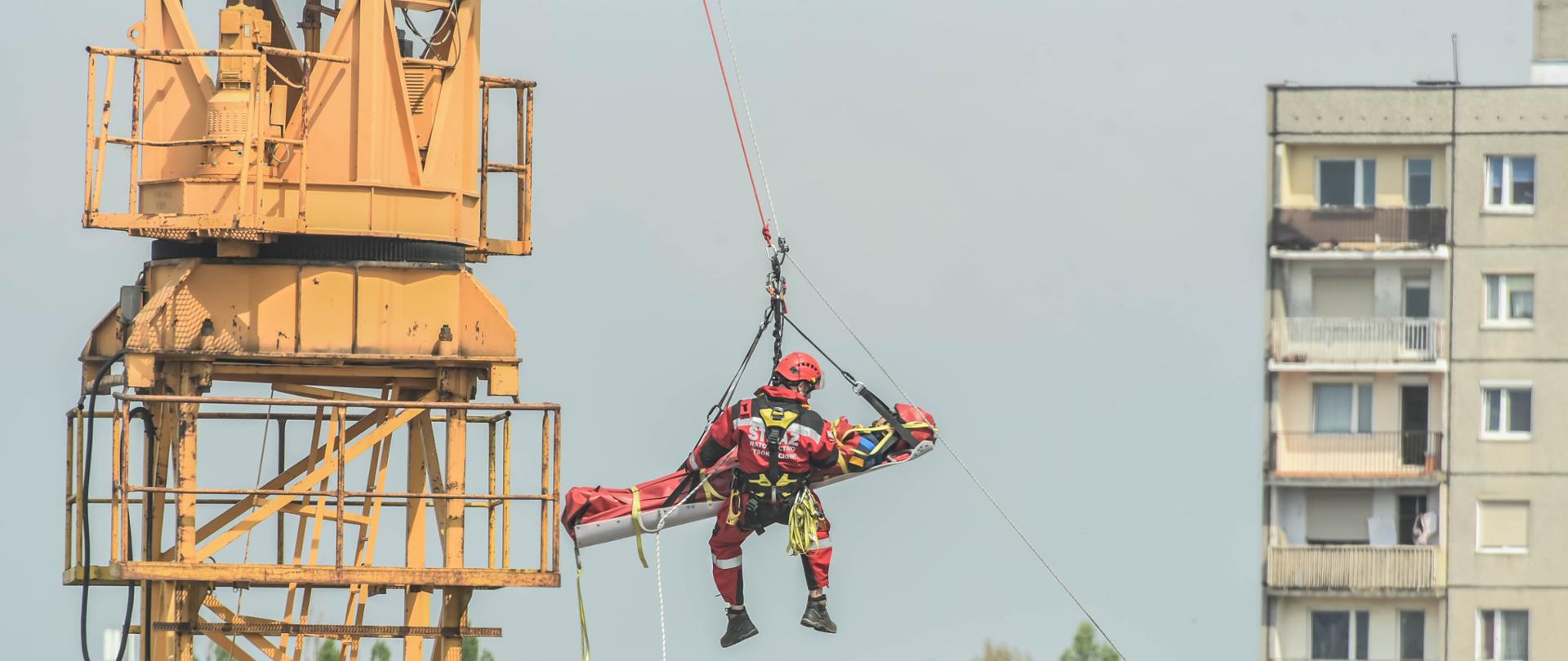 Pokazy Grupy Ratownictwa Wysokościowego JRG1 - strażacy powoli opuszczają poszkodowanego