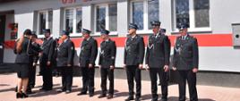 Oficjalne rozpoczęcie uroczystości przed odnowionym budynkiem remizy Ochotniczej Straży Pożarnej w Żeleźnikach (rok założenia 1926). Na placu w równym szyku stoją druhowie OSP w pełnym umundurowaniu galowym. Po lewej stronie widoczny jest moment składania raportu lub wręczania wyróżnień.