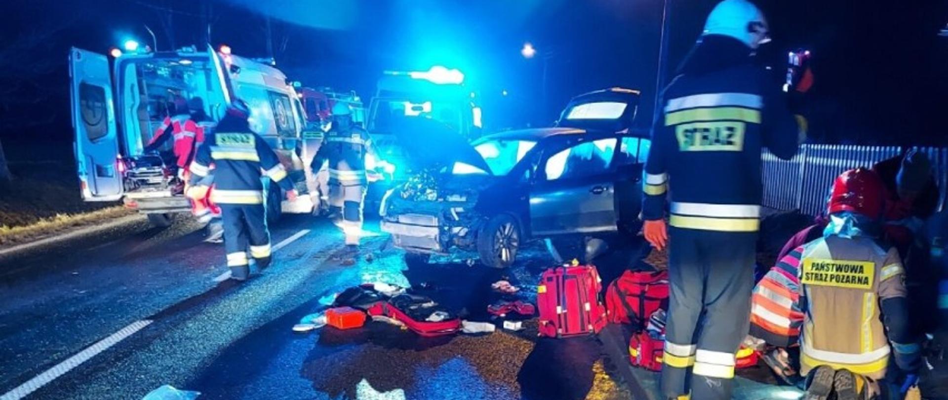 Ratownicy Państwowej Straży Pożarnej udzielają pomocy osobie poszkodowanej