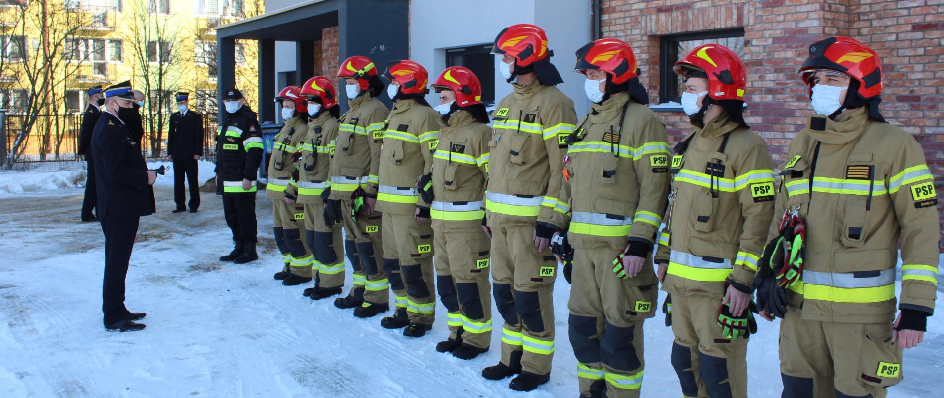 2. Uroczysta zbiórka przed budynkiem Komendy Powiatowej Państwowej Straży Pożarnej w Świeciu na powitanie Kujawsko-Pomorskiego Komendanta Wojewódzkiego starszego brygadiera Jacka Kaczmarka. Na pierwszym planie w szeregu stoi zmiana służbowa w ubraniach specjalnych. Na drugim planie na początku szeregu Dowódca Jednostki Ratowniczo-Gaśniczej młodszy brygadier Paweł Puchowski. W tle bokiem stoi Komendant Powiatowy starszy brygadier Piotr Tkaczyński wraz ze swoim Zastępcą starszym brygadierem Andrzejem Rafalskim. 