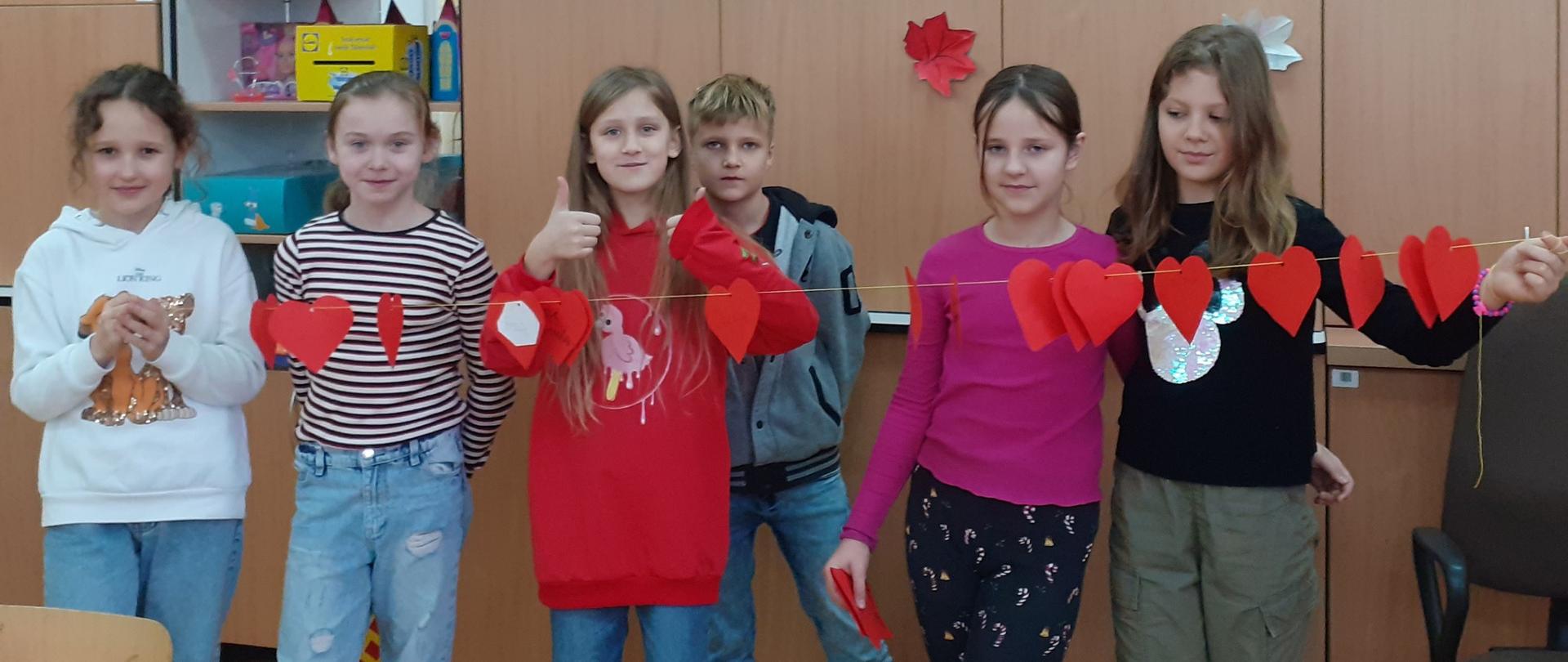 Zdjęcie dzieci w świetlicy na tle szafek.