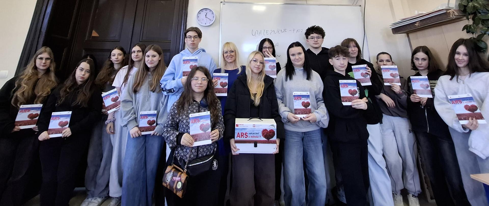zdjęcie grupowe uczniów klasy pierwszej w gabinecie z ulotkami promującymi program