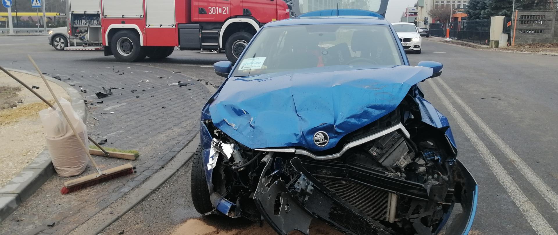 Na zdjęciu przedstawiono jeden z samochodów biorących udział w kolizji drogowej. Widać rozsypany sorbent w celu usunięcia plamy płynów eksploatacyjnych.