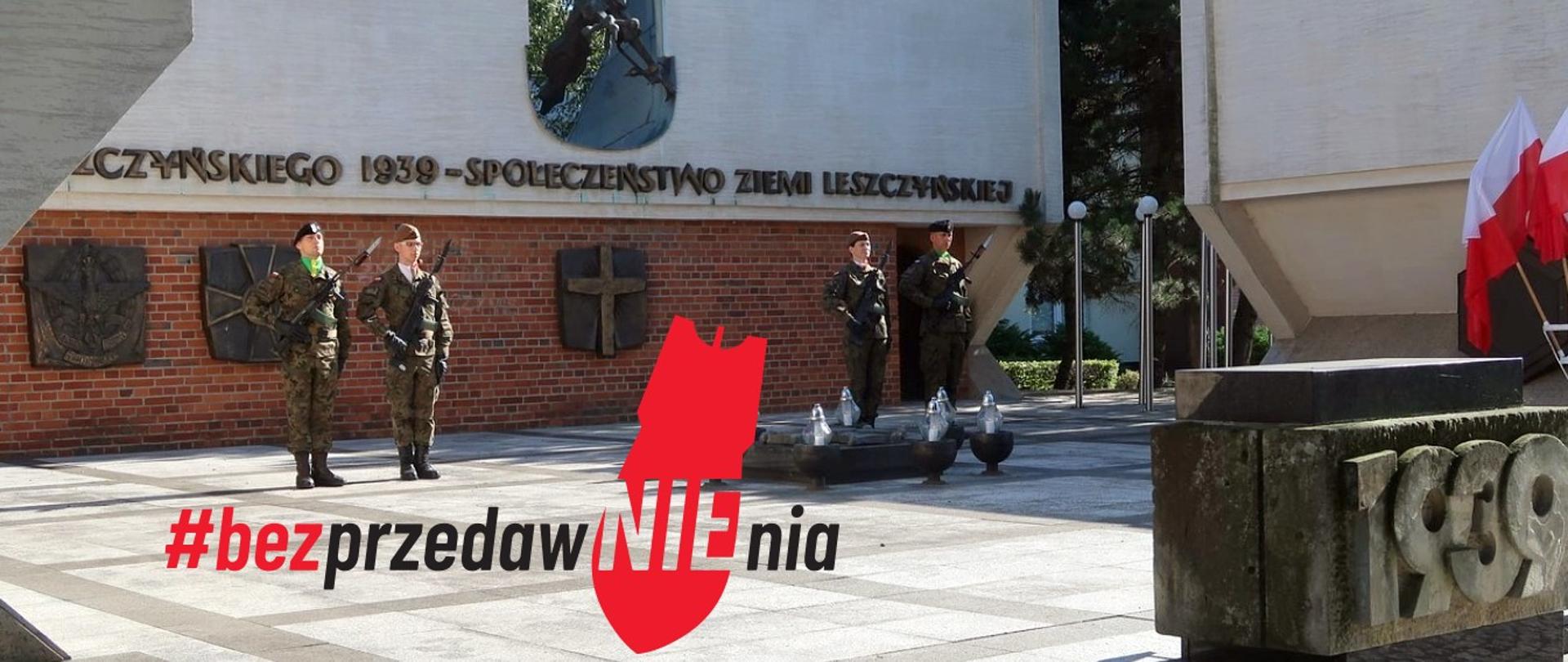 Zołnierze stoją na baczność przed pomnikiem upamiętniającym wybuch II Wojny Światowej