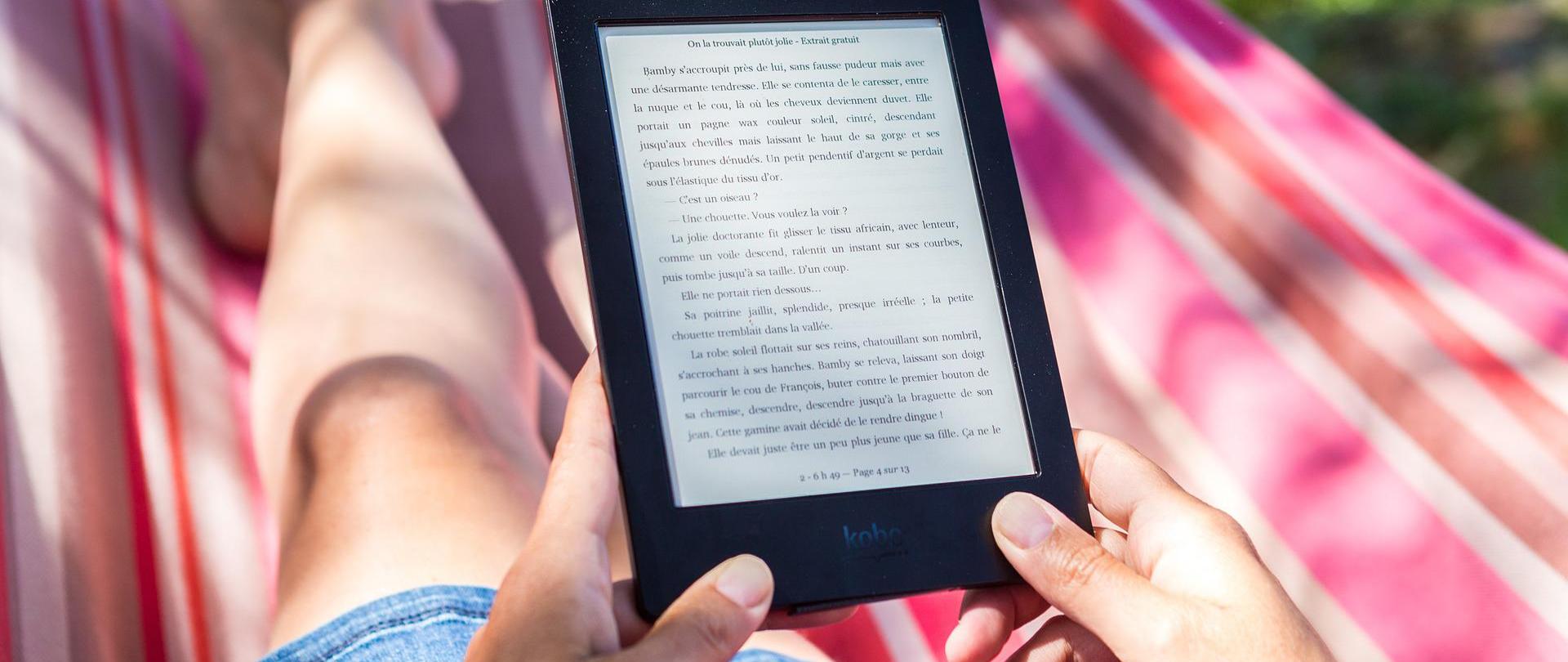 Zdjęcie w poziomie. Kobieta na hamaku czytająca książkę.