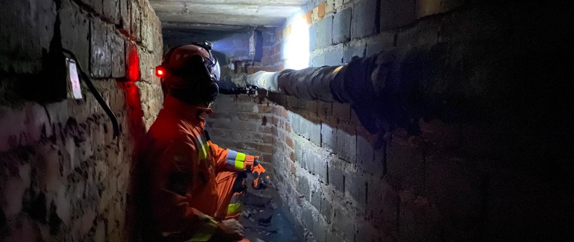 Strażak kucający w ciemnym tunelu