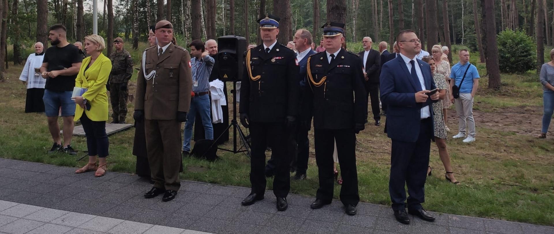 Na zdjęciu widoczny jest Zastępca Mazowieckiego Komendanta Wojewódzkiego PSP st. bryg. Tomasz Cybul oraz Komendant Powiatowy PSP st. bryg. Bogusław Majchrzak. Obaj panowie biorą udział w uroczystości odsłonięcia popiersia tragicznie zmarłego w katastrofie smoleńskiej. 