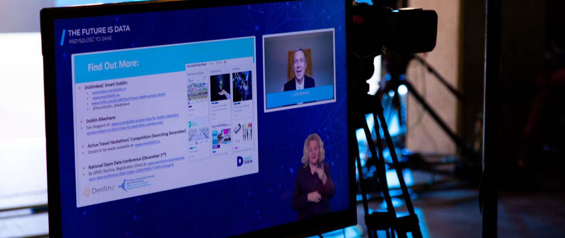 Monitor komputera, na którym widać panelistę oraz tłumaczkę języka migowego.