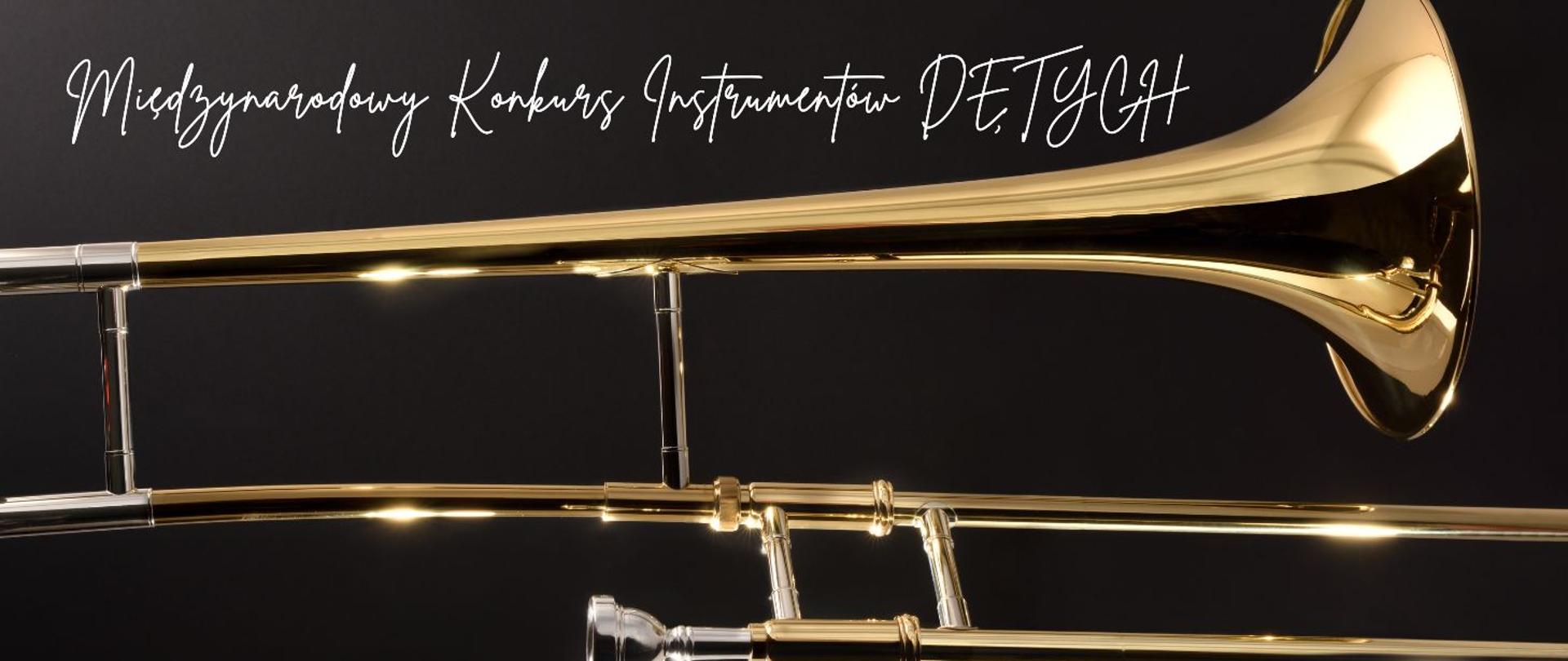 Na grafice widać fragment puzonu — instrumentu dętego blaszanego o złotym, błyszczącym kolorze. Tło jest ciemne, co podkreśla połysk metalu. U góry znajduje się napis w eleganckim, odręcznym stylu: „Międzynarodowy Konkurs Instrumentów Dętych”. 