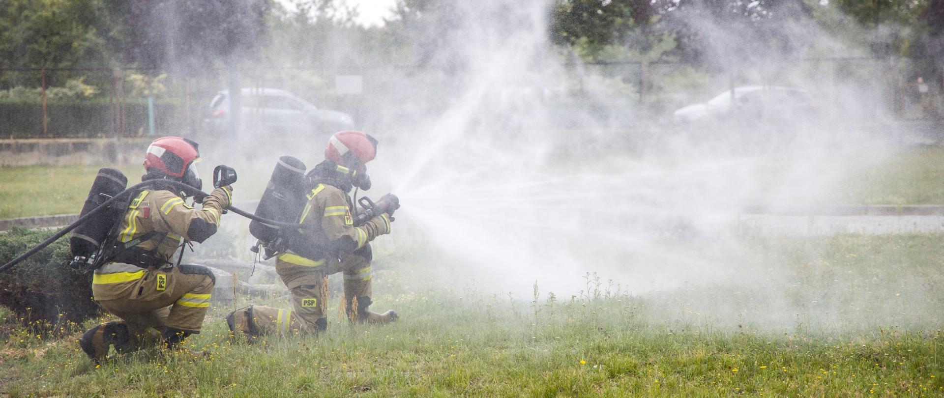 Strażacy PSP z JRG Brzeg zabezpieczeni w aparat ochrony układu oddechowego oraz ubranie bojowe wykonują podejście z tzw. parasolem wodnym do płonącej cysterny podczas ćwiczeń pk. "Kruszwica 2022", które to odbywały się 8 lipca 2022 roku.