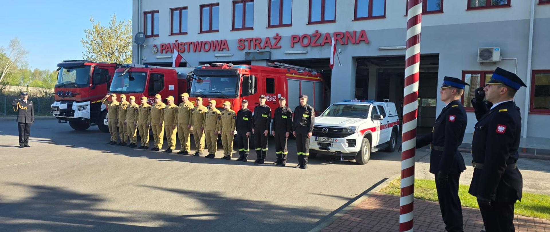 Na zdjeciu widoczny jest poczet flagowy oraz funkcjonariusze Państwowej Straży Pożarnej z Komendy Powiatowej w Ostrowcu Świętokrzyskim podczas obchodów dnia flagi Rzeczyspopolitej Polskiej.