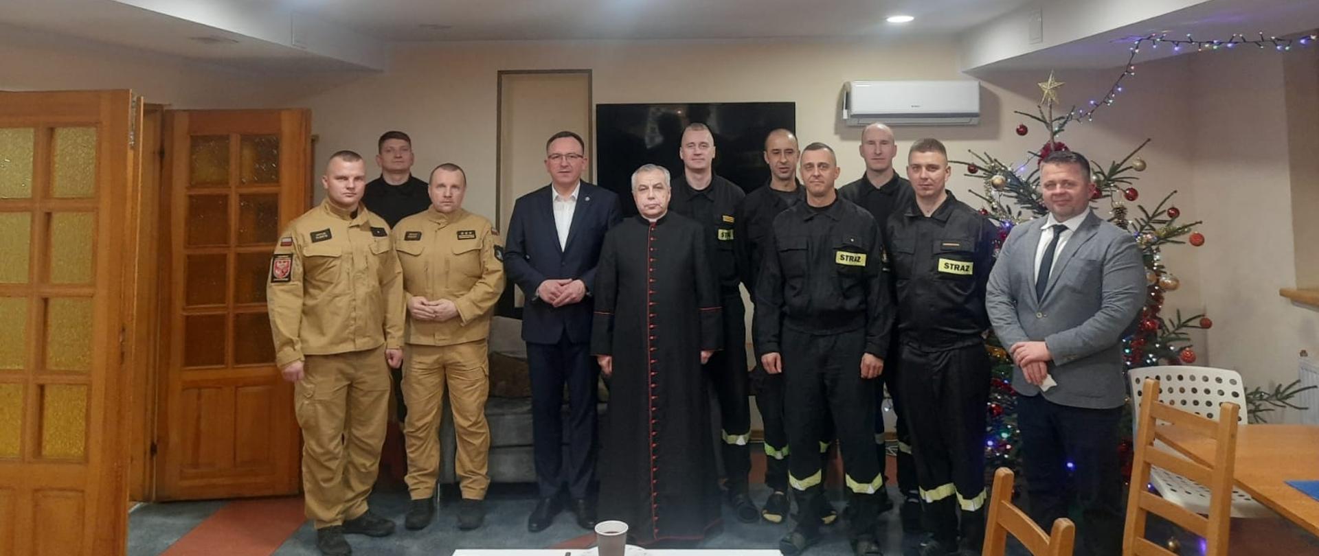 Na zdjęciu ze strażakami pełniącymi w dniu wigilii służbę, kapelan strażaków, burmistrz Braniewa oraz komendant powiatowy.