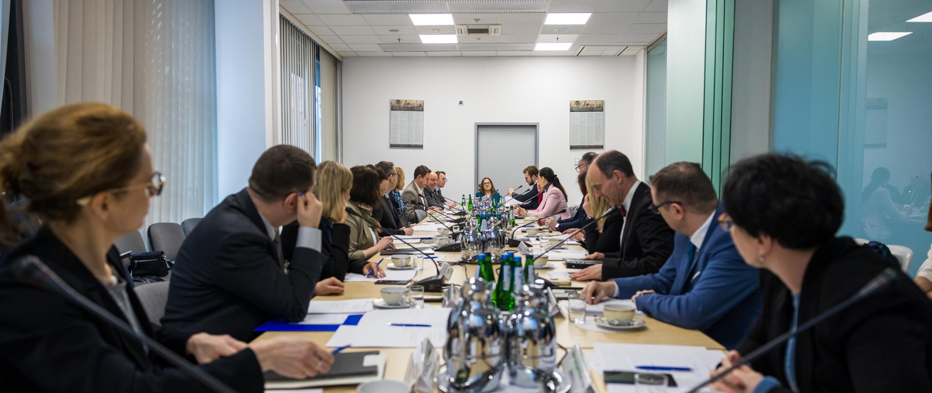 Ludzie siedzą przy długim stole