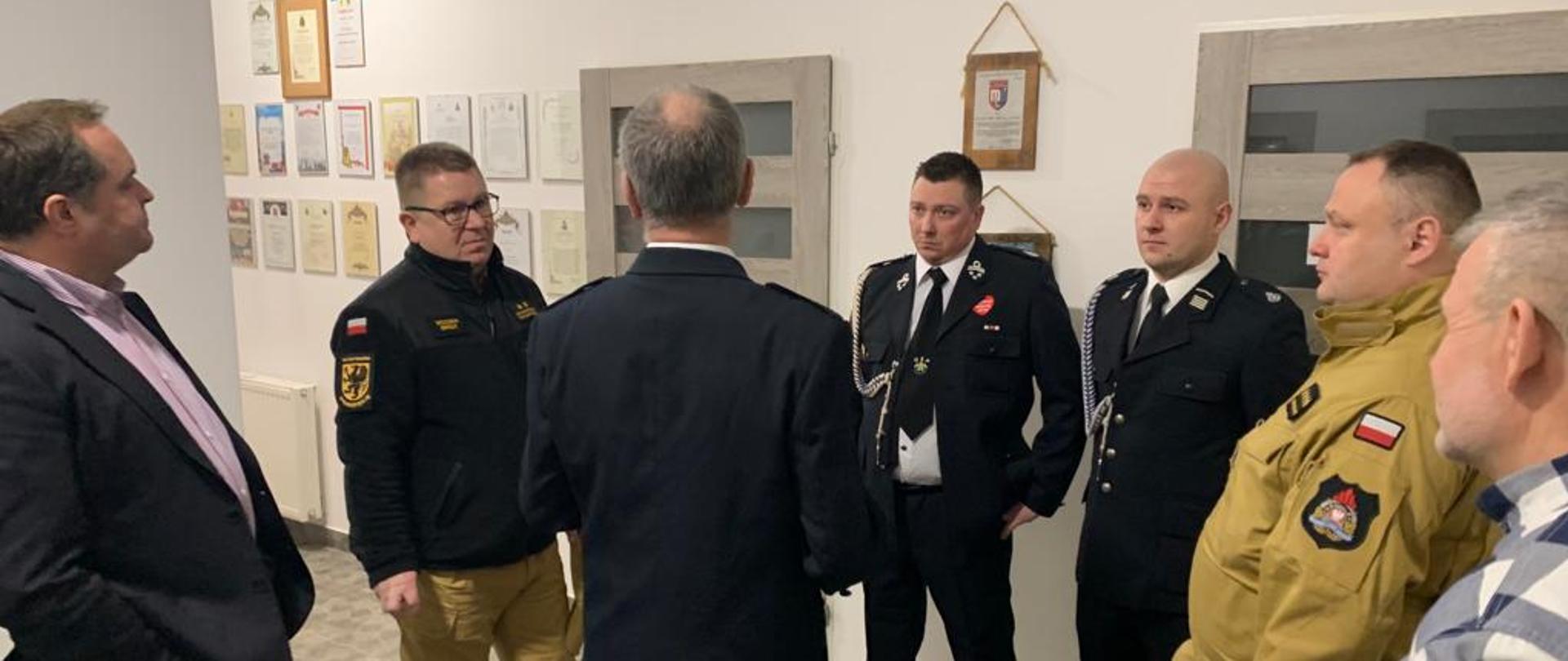 Fotografia przedstawia osoby stojące w kręgu.