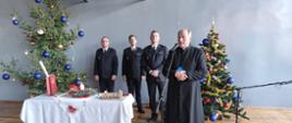 Na zdjęciu na tle choinek, Komendant Miejski Państwowej Straży Pożarnej w Częstochowie wraz z zastępcami oraz kapelan częstochowskich strażaków