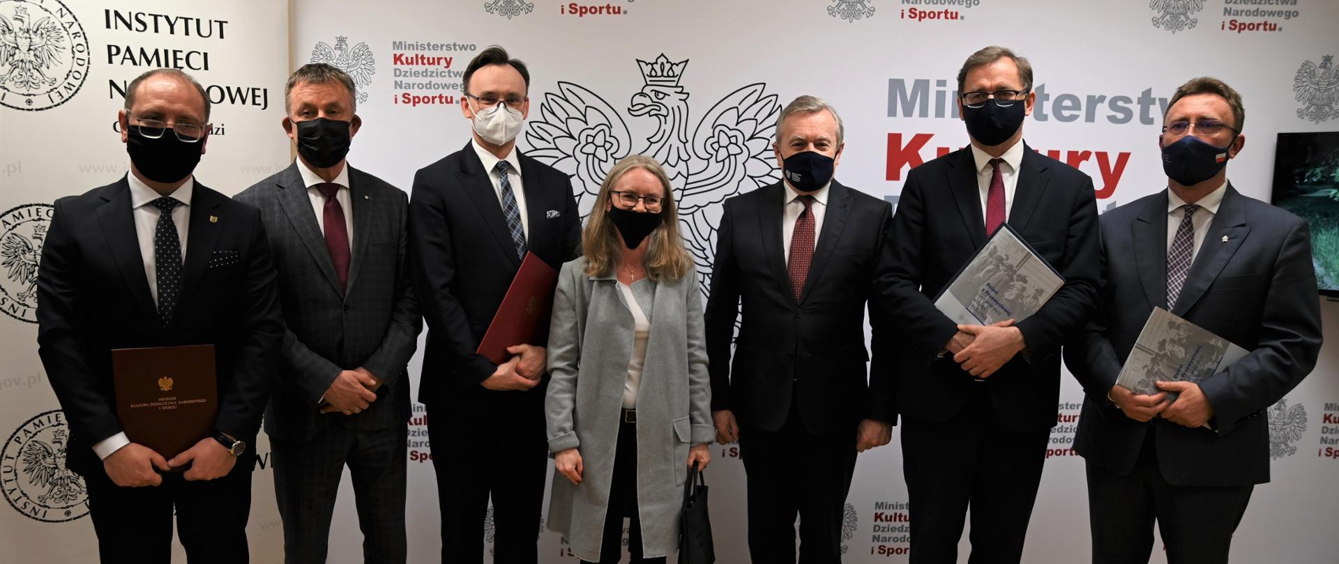 Na zdjęciu stoją (od lewej): dr Ireneusz Piotr Maj, wicewojewoda łódzki Karol Młynarczyk, Rzecznik Praw Dziecka Mikołaj Pawlak, Jolanta Sowińska-Gogacz - członek Rady Programowej ds. Upamiętnienia Dzieci Polskich z Obozu w Łodzi, wicepremier, minister kultury, dziedzictwa narodowego i sportu Profesor Piotr Gliński, dr Jarosław Szarek – prezes Instytut Pamięci Narodowej, dr hab. Dariusz Rogut – dyrektor oddziału IPN w Łodzi.