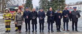Ministra, Posła, komendantów Państwowej Straży Pożarnej, burmistrza Ponieca oraz druhów OSP pozujących do zdjęcia. Za nimi stoi wóz strażacki.