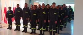 Zdjęcie przedstawia strażaków podczas wręczania dyplomów w sali komendy.