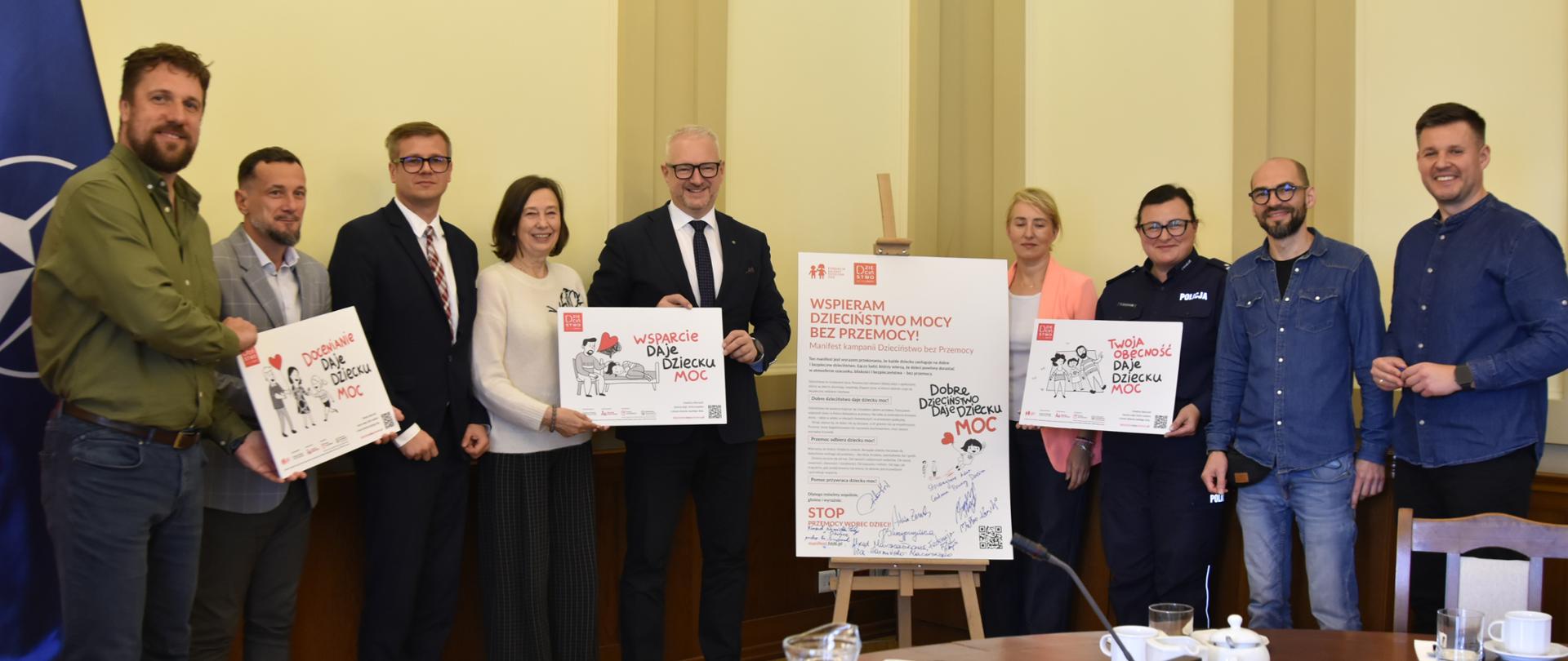 Uczestnicy wydarzenia pozują do wspólnego zdjęcia przy podpisanym manifeście.