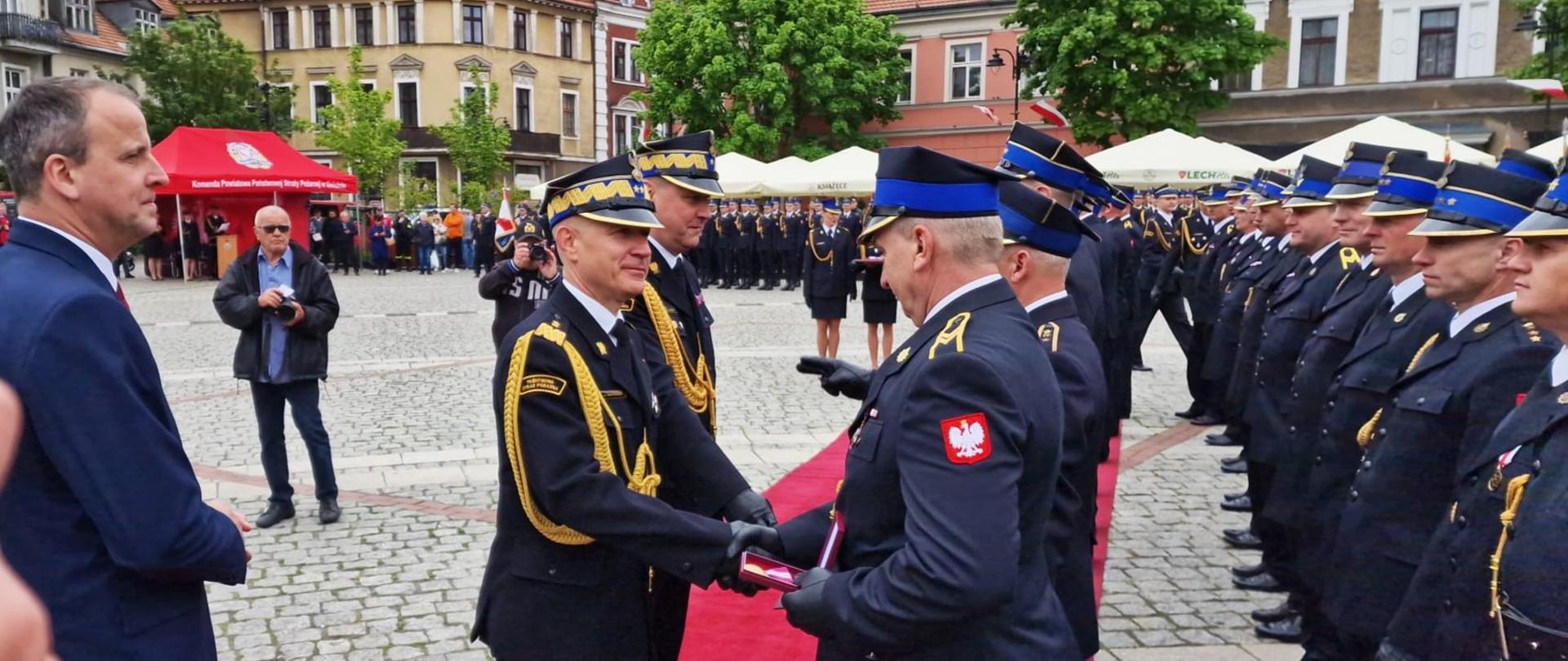 Komendant główny PSP wraz z komendantem wojewódzkim PSP wręczają strażakom odznaczenia i wyróżnienia