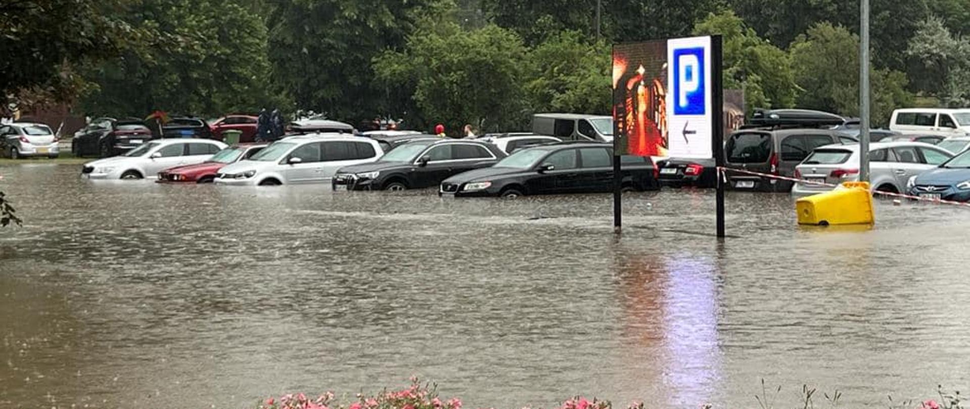 Na zdjęciu widoczne auta na parkingu stojące w wodzie