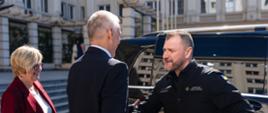 Zdjęcie przedstawia trzy osoby. Witają się ze sobą minister Tomasz Siemoniak (w środku, tyłem) i Ihor Klymenko, sekretarz Rady Bezpieczeństwa Narodowego i Obrony Ukrainy (po prawej). Z boku po lewej stronie stoi Teresa Kubas-Hul, wojewoda podkarpacka. Za ministrami widać czarny samochód, a w tle budynek Urzędu Wojewódzkiego w Rzeszowie.