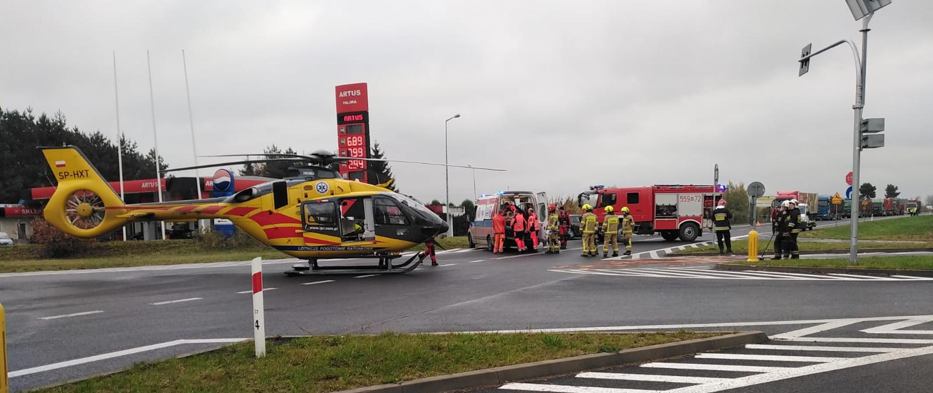 Wypadek na drodze wojewódzkiej 801 w miejscowości Sobienie Biskupie. Widoczny jest śmigłowiec LPR oraz strażacy na środku skrzyżowania DW 801.