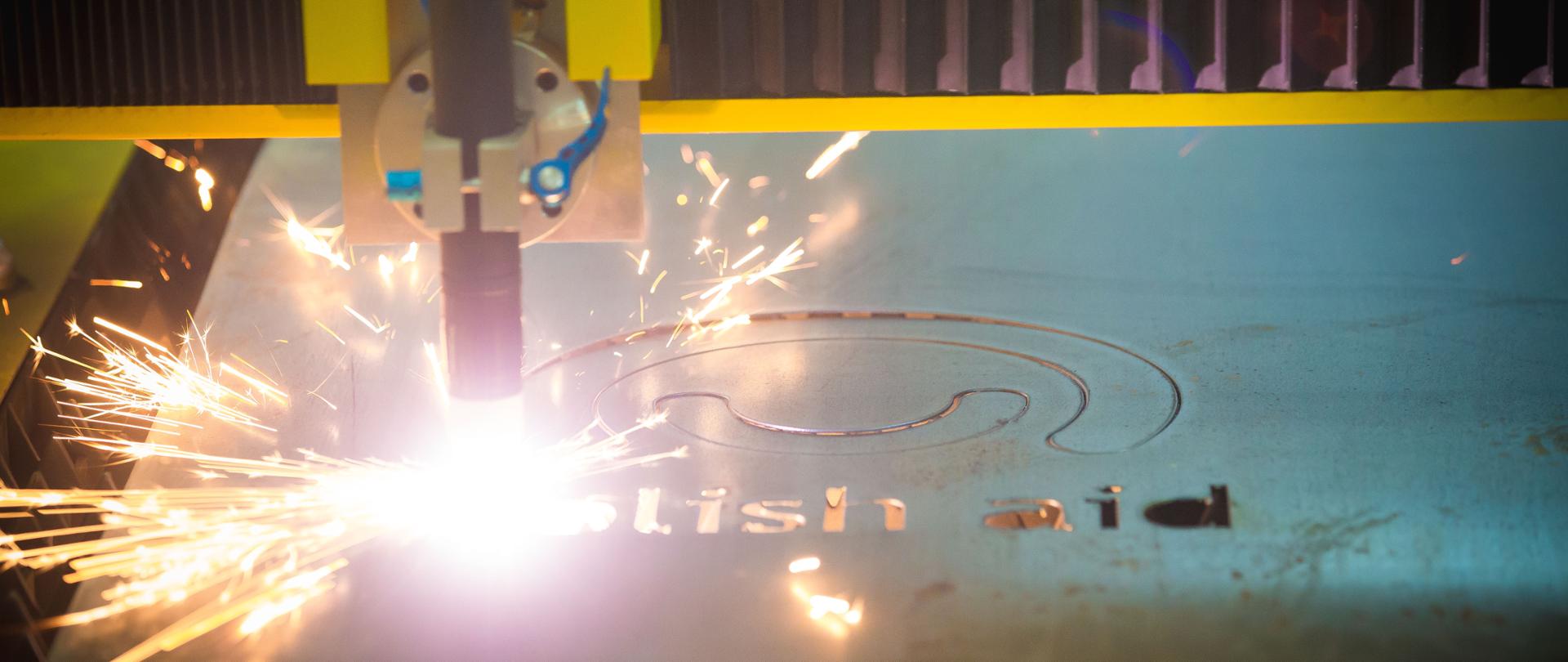 laser wycina znak logo Polish Aid